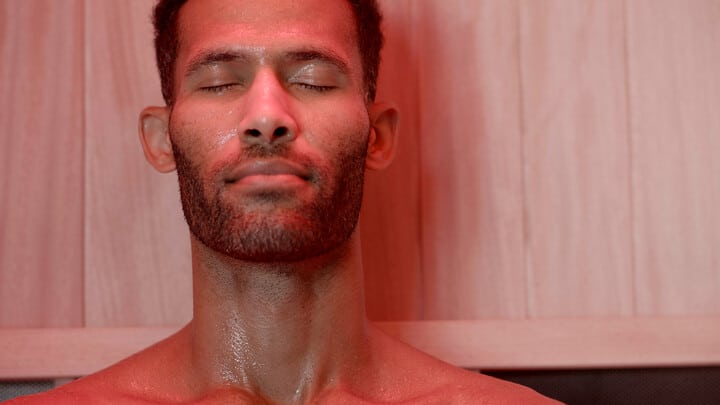 man in an infrared home sauna with red light therapy